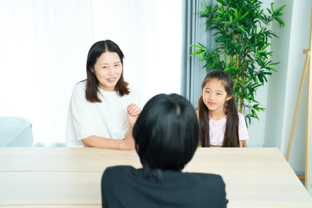 一个穿着西装的女人与父母和孩子的对话场景图片下载