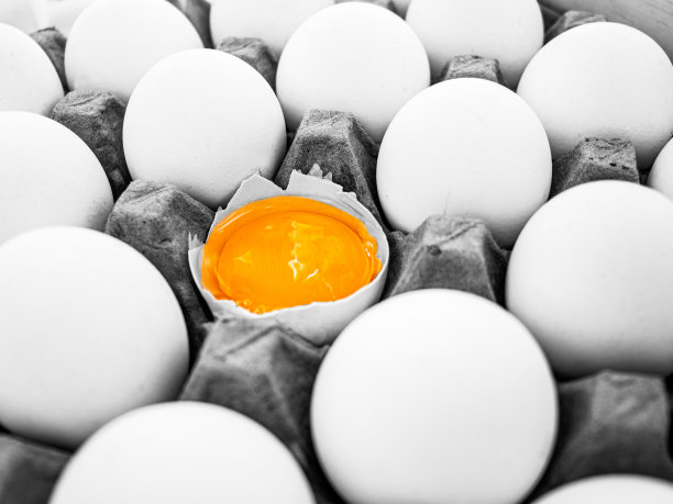 鸡蛋盒里的鸡蛋，特写，破裂的鸡蛋，从人群中脱颖而出的概念，黑白照片，图片下载