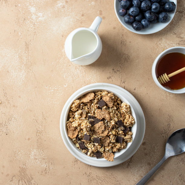 健康早餐俯视图。天然格兰诺拉麦片，由未加工的全谷物与巧克力、蓝莓、蜂蜜和牛奶混合而成图片下载