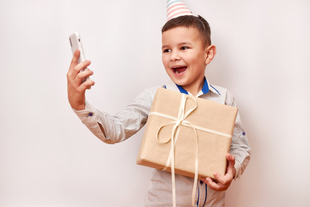 小男孩拿着礼物自拍。生日庆祝概念。图片下载