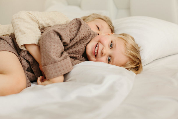 男孩，躺在床上玩，玩得很开心图片下载