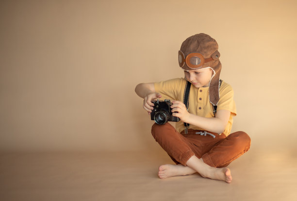 一个小学年龄的男孩手里拿着相机拍照图片下载