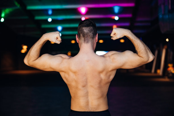 健美赤膊男子展示背阔肌、肩部和二头肌图片下载
