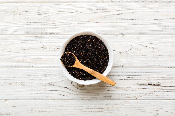 奎奴亚藜籽在碗和勺子在彩色背景。小碗里的健康金蛙。健康的超级食物图片下载