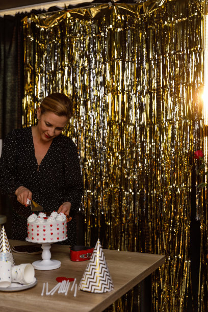 一位女士正在切一块装饰着爱心的蛋糕图片下载