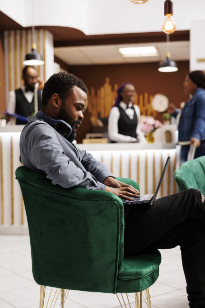 在酒店大堂拿着笔记本电脑的自由职业者图片下载