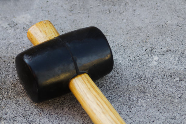 散焦铺路锤近景。花园砖路。砂土基础上院落灰色混凝土铺装板的铺设。没有人。焦距不清图片下载