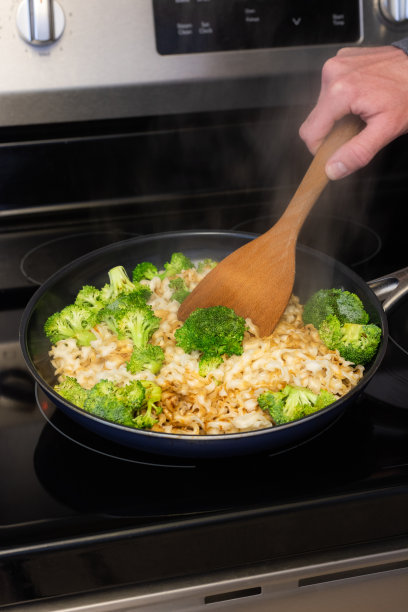 烹饪西兰花，在灶台上翻炒图片下载