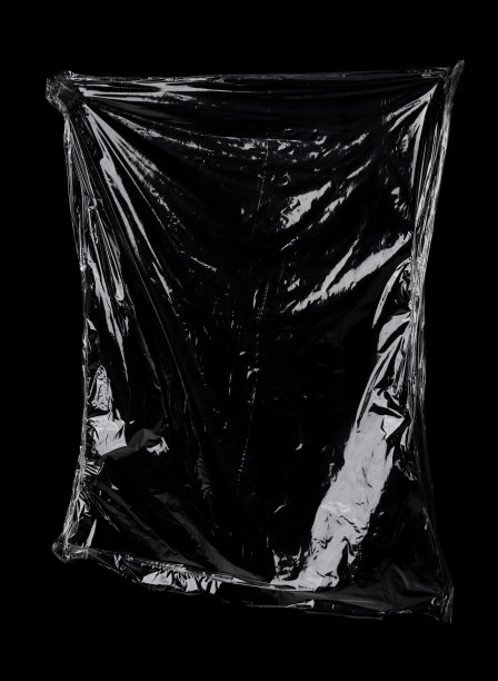 透明的保鲜膜纹理在黑色背景上。塑料袋质感。可重复使用的垃圾和废物。图片下载