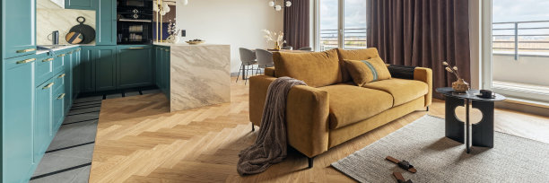 创意和现代复古开放空间室内设计与黄色沙发和绿松石厨房与大理石岛。人字形拼花地板上铺着灰色的地毯和咖啡桌，窗户上挂着棕色的窗帘。模板。图片下载