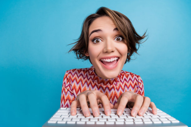 可爱的年轻女士的照片肖像打字键盘笔记本电脑摄像头近距离穿着时髦的条纹服装孤立的蓝色背景图片下载