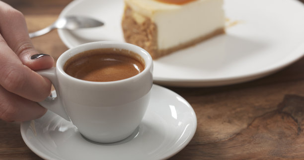 少女吃着加焦糖的芝士蛋糕，喝着咖啡图片下载