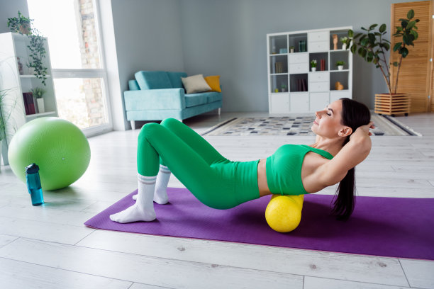 全身侧面照片的决心苗条的女士做腹肌锻炼健身滚轮地毯客厅室内图片下载
