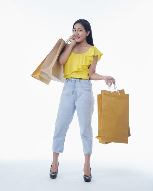 漂亮的年轻女子拿着白色背景的购物袋图片下载