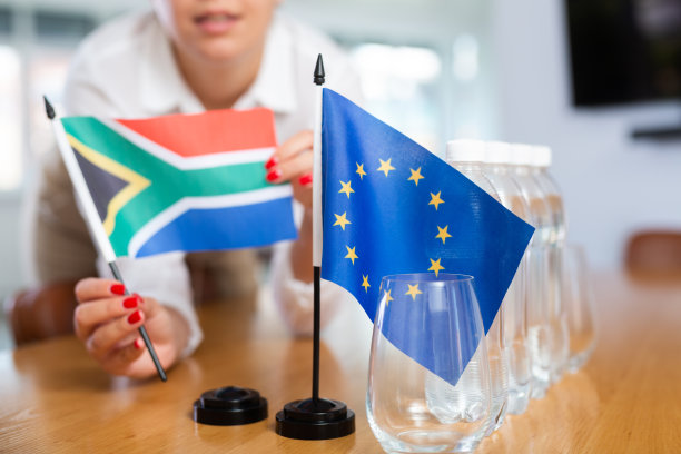 女秘书在高层政治人物谈判前将南非国旗和欧盟国旗放在桌子上图片下载
