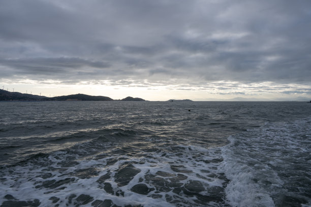 黄昏时，一艘客船在蓝色的波浪上航行。图片下载