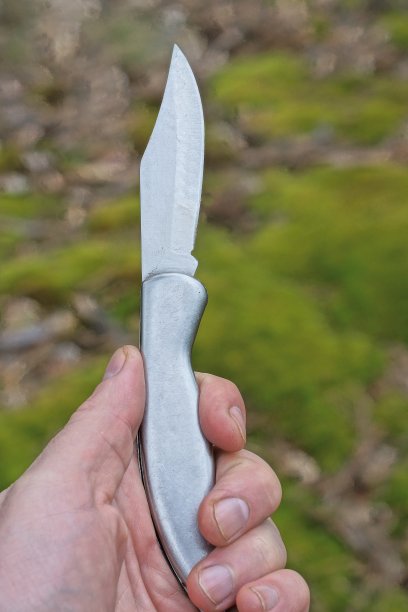 手里拿着一把灰色的金属折叠刀图片下载