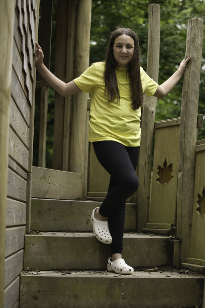 一个十几岁的女孩在树林里玩玩具图片下载