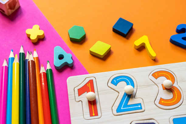 彩色纸上的木制儿童玩具。益智玩具积木，金字塔，铅笔，数字。幼儿园、学前班或日托所的玩具。文本的复制空间。俯视图图片下载