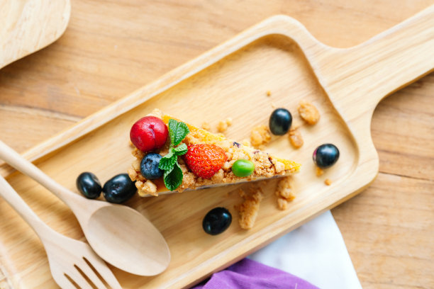 切成薄片的浆果芝士蛋糕装在木盘上。图片下载