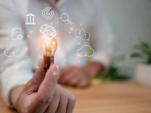 一个人拿着一个灯泡。它代表了教育、学习、创新和成功的概念。图片下载