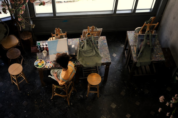 受启发的女艺术家在画布上作画，独自在艺术工作室享受创作的乐趣。图片下载