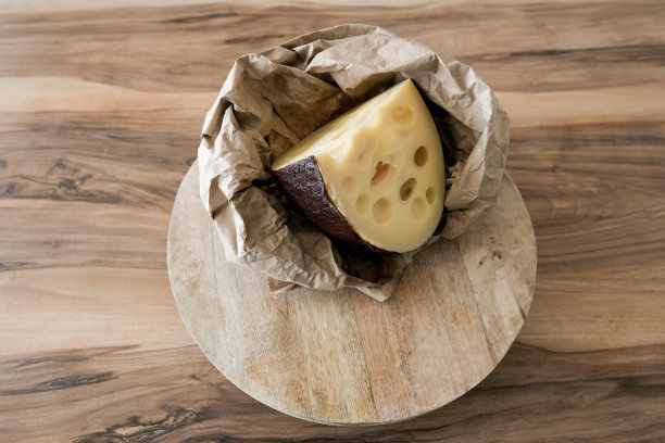 一块基本的奶酪放在手工纸袋上图片下载