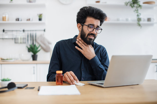发烧男子通过笔记本电脑与全科医生进行虚拟预约图片下载