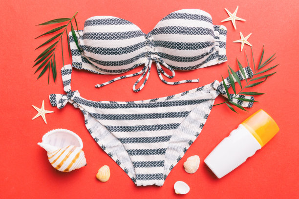女子泳装和沙滩配饰平铺上视图彩色背景夏季旅游概念。比基尼泳衣，草帽和高跟鞋。复制空间俯视图图片下载