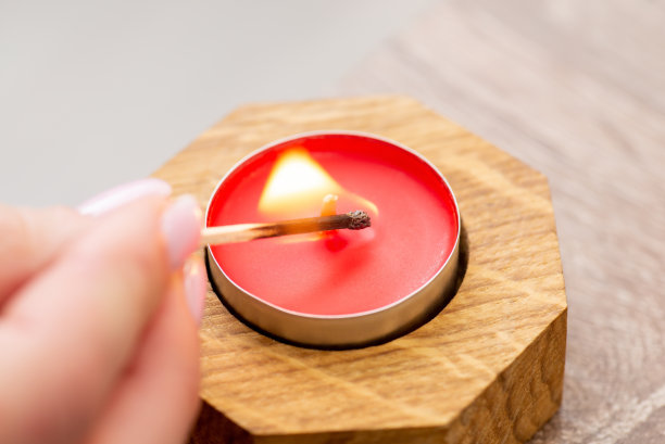 小红烛插在木烛台上，女孩用火柴把它点着，凑近了图片下载