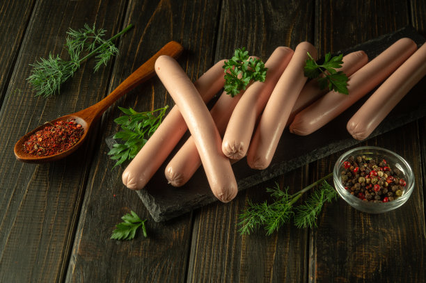 分拣板上的许多煮熟的香肠是用香料和草药准备的晚餐。又快又好吃的零食点子图片下载
