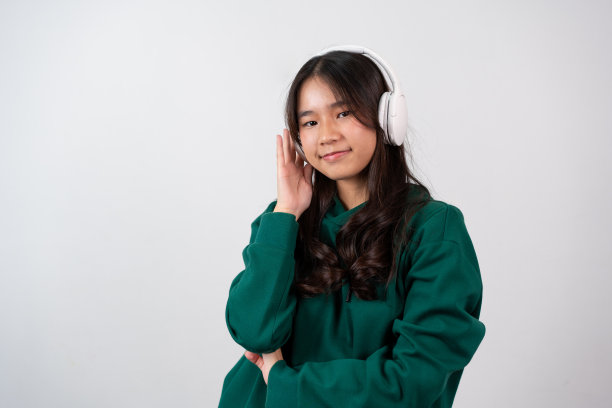 一个快乐、迷人、无忧无虑、快乐的十几岁的女孩在白色的背景上玩得很开心，轻松地跳舞和微笑，高兴地举起双臂，被娱乐和娱乐孤立。图片下载