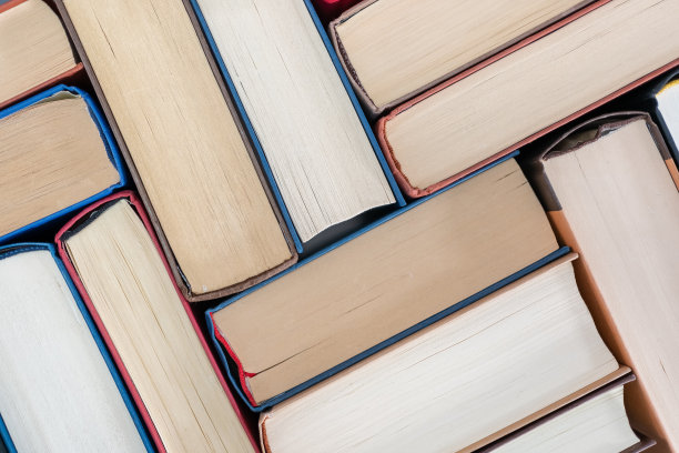 许多书摆放在一张桌子上，俯视图的照片。图片下载