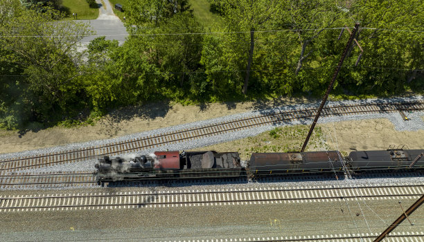 一辆蒸汽机车在货场内移动货物车厢的鸟瞰图图片下载