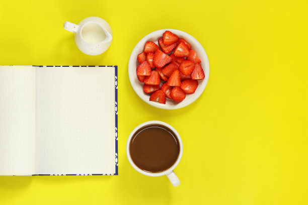 舒适的工作空间。在黄色背景上打开记事本的模型。平躺图片下载