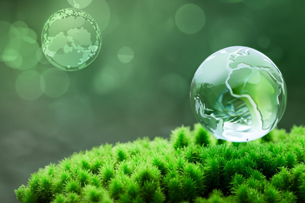 地球日，手握绿色地球，以绿色为背景，环保生态永续。拯救地球世界环境日的概念图片下载