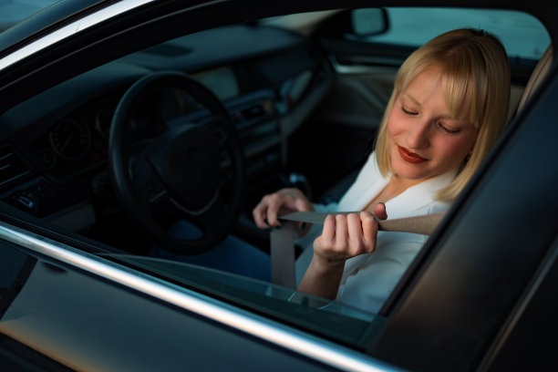 一位女商人坐在车里系上安全带的照片图片下载