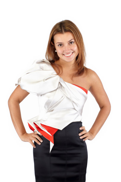 穿着黑白红裙子的年轻美女微笑着站在那里看着镜头。工作室拍摄，大腿中部剪裁，孤立在白色中图片下载