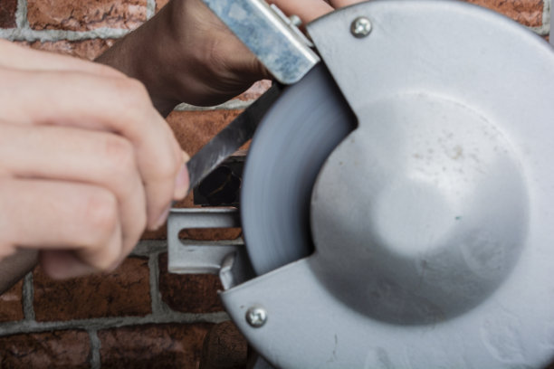 木桌上的磨刀手和刀片，特写图片下载