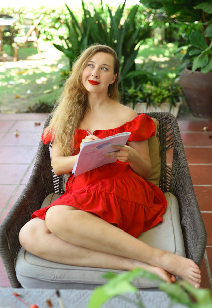 美丽的金发女郎，艺术家和插画家，坐在沙发上思考绘画的想法图片下载