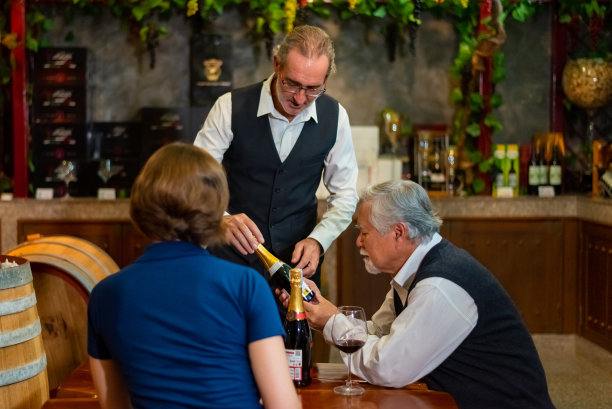 资深侍酒师在葡萄酒店向顾客推荐葡萄酒。图片下载