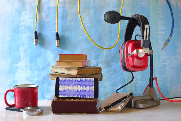 用老式耳机和麦克风录制播客或有声书，智能手机屏幕和音频电缆上的波形。图片下载