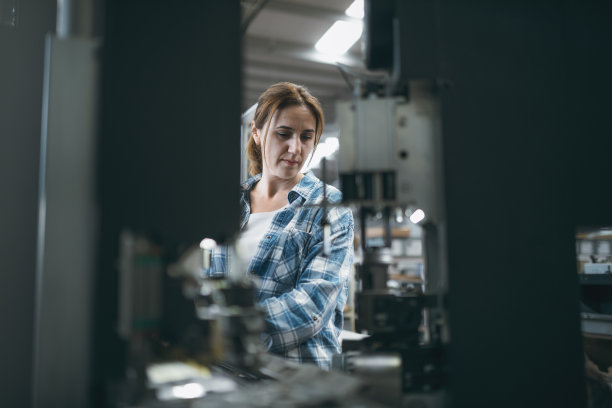 在工厂里操作制造设备的女工业工人图片下载