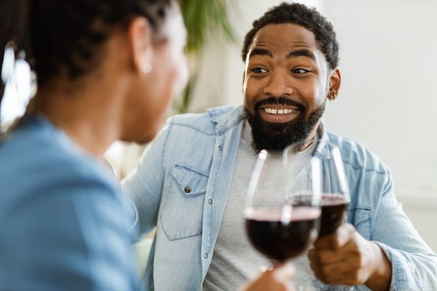 幸福的黑人夫妇在家里用红酒干杯图片下载