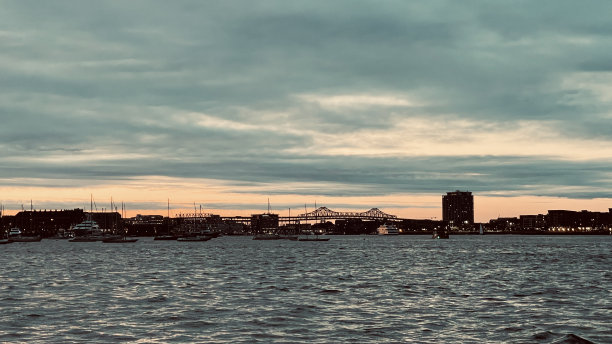 2023年6月，马萨诸塞州波士顿市中心的日落傍晚照片，有高层建筑和水中的倒影图片下载