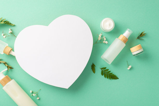 草本天然化妆品概念。空心形的俯视图照片，可回收的化妆品容器和蕨类植物，桉树和gypsophila树枝在孤立的绿松石背景与copyspace图片下载