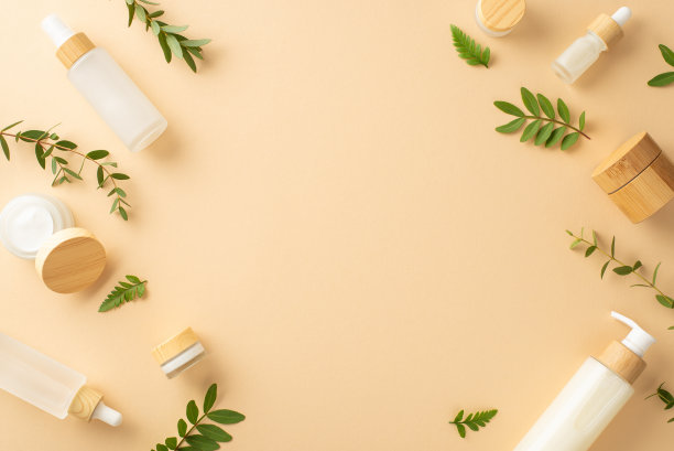 环保化妆品概念。俯视图照片，被化妆品容器包围的空地方，桉树和蕨类植物叶子在孤立的米色背景上与copyspace图片下载