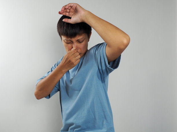 男子汗流浃背，腋窝潮湿，体臭，盖住鼻子图片下载