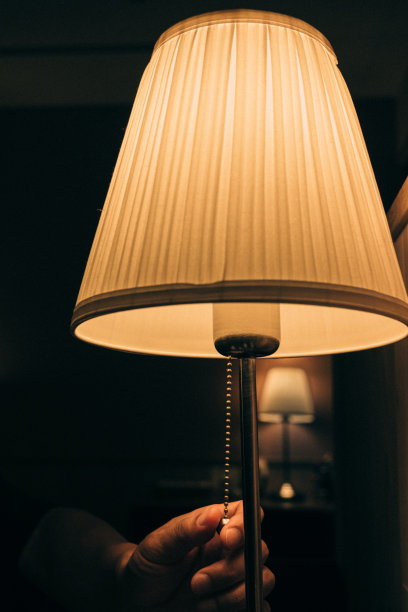 一个人的手在黑暗的房间里打开灯的图像图片下载