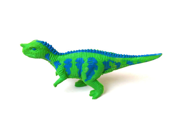 白色背景上的绿色恐龙玩具的特写。图片下载